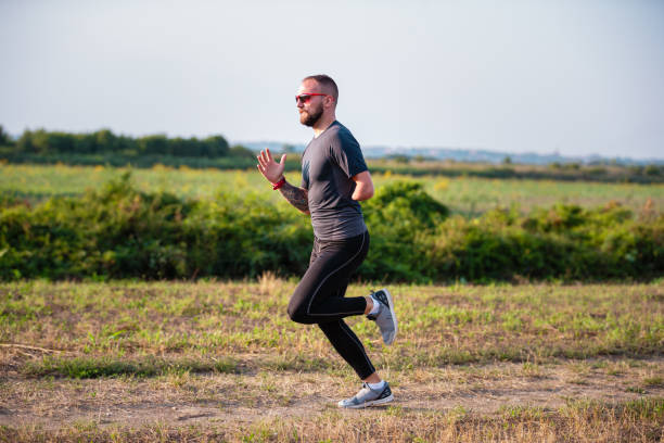 istock Physically impaired young man running outdoors for warm up 1302598881