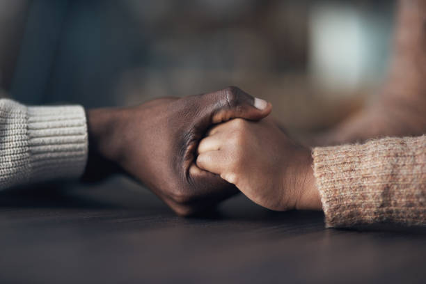 Seek comfort in me, my love Cropped shot of an unrecognizable couple holding hands while at home during the day supported stock pictures, royalty-free photos & images