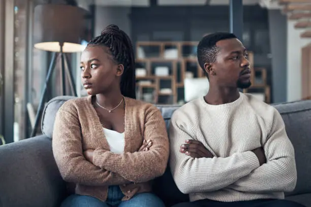 Cropped shot of a young couple sitting on the sofa and giving each other the silent treatment after an argument