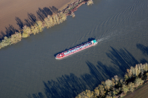 Aerial viwy of barges sailing on the Seine river, in commune of Haute-Isle en Vexin, Val-d'Oise department (95780), Ile-de-France, France - January 03, 2010