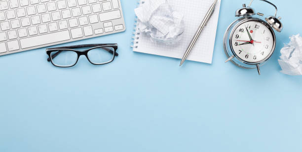 istock Office desk with supplies, alarm clock and blank notepad 1302602682
