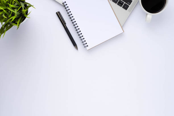 istock Top view above of White office desk table with keyboard, notebook and coffee cup with equipment other office supplies. Business and finance concept. Workplace, Flat lay with blank copy space. 1302604523