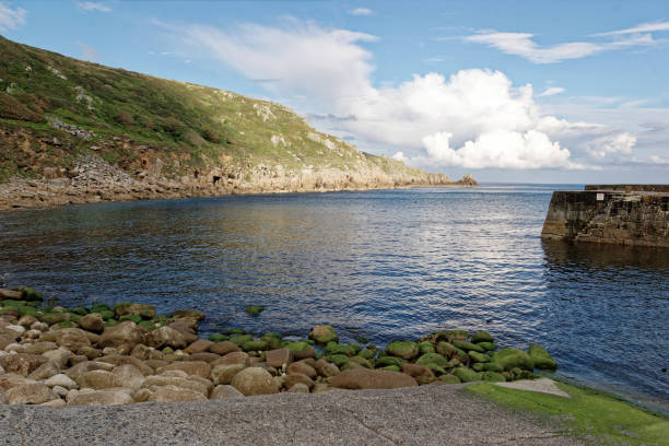 Lamorna Cove Cornwall England The quay, sea and cliffs at Lamorna Cove, Cornwall England. Calm waters in the bay with remains of stones from quarrying littering the hillside and seashore. Late afternoon.. lamorna cove stock pictures, royalty-free photos & images