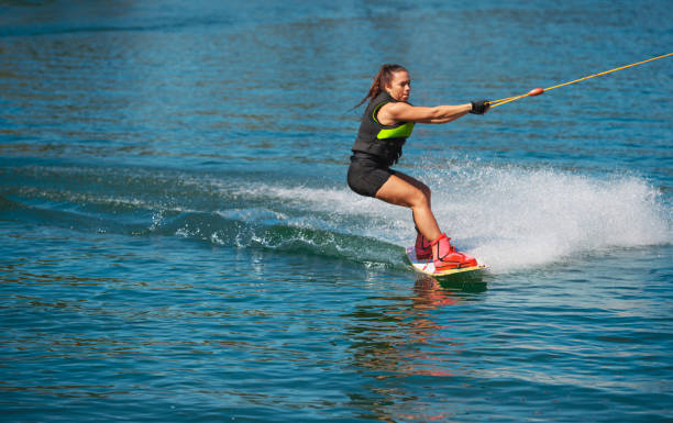 istock Female wakeboarder reclining to slow down and splashing 1302606666