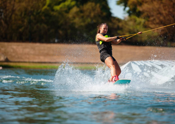 istock Muscular young woman wakeboarding pulled by towing rope 1302606691