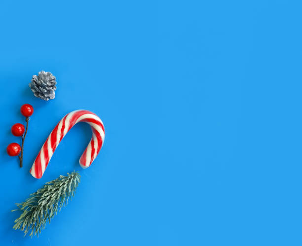 istock Christmas tree branch, candies on a colored background 1302610351