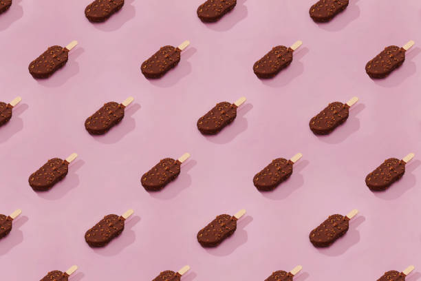 istock Chocolate ice-cream on a stick on pink background. 1302611753