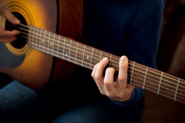 istock Close-up woman playing acoustic guitar. Selective focus 1302614979