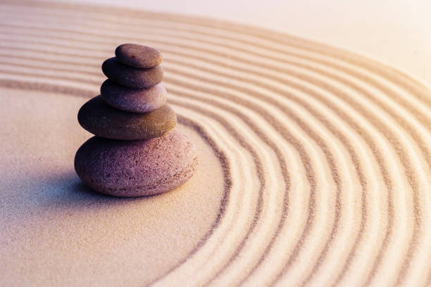 istock Meditation zen garden with stones on sand 1302619376