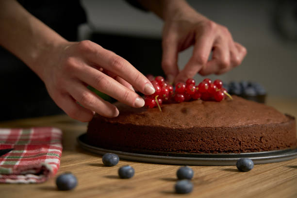 istock Woman with a passion for cooking decorates handmade chocolate cake. 1302620083