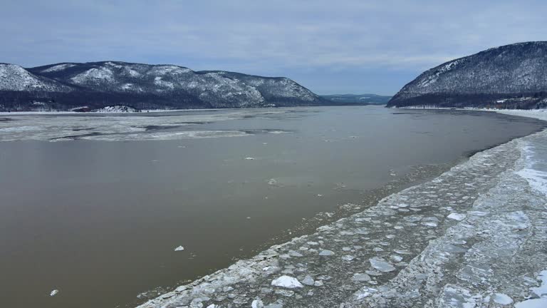 Aerial drone footage of an icy river valley in winter