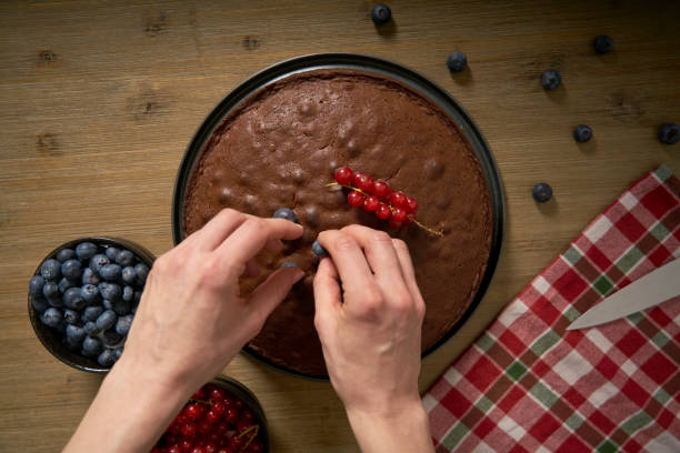 istock Woman with a passion for cooking decorates handmade chocolate cake. 1302620417