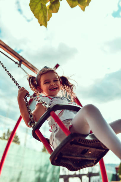 istock Cute Female Child Enjoying Playground Swing Fun 1302620573
