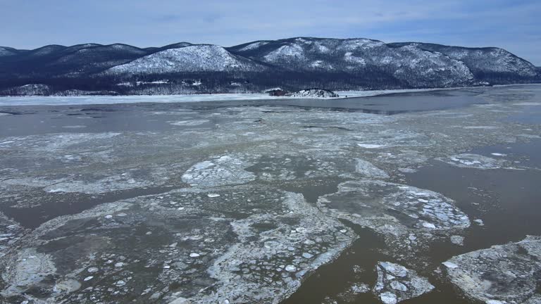 Aerial drone footage of an icy river valley in winter