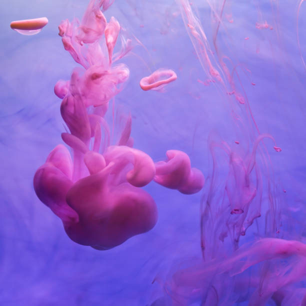 istock Pink inks in water on blue background 1302620779