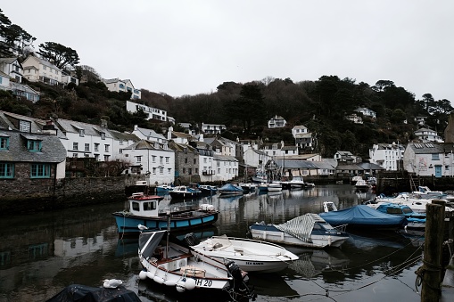 the view from across the harbour wall towards the small fishing boats in mevagissey harbour in winter