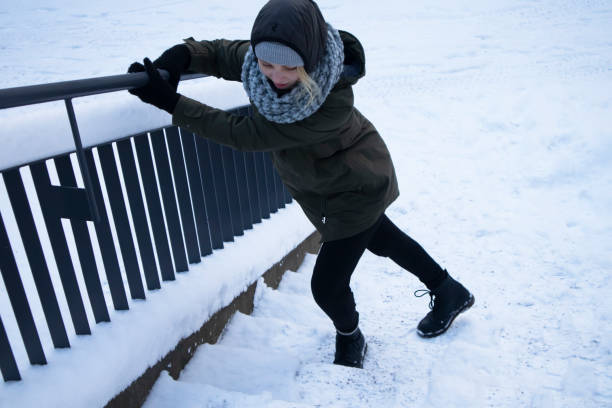 Woman walking up a snow-covered staircase