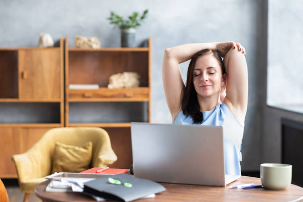 business woman stretches her body doing yoga exercise at coffee break. - yoga business women indoors imagens e fotografias de stock