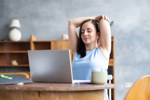 la femme d’affaires étire son corps faisant l’exercice de yoga à la pause-café. - yoga business women indoors photos et images de collection