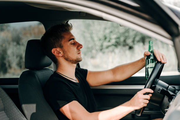 hombre bebiendo cerveza mientras conducía - drunk driving accident teenager fotografías e imágenes de stock