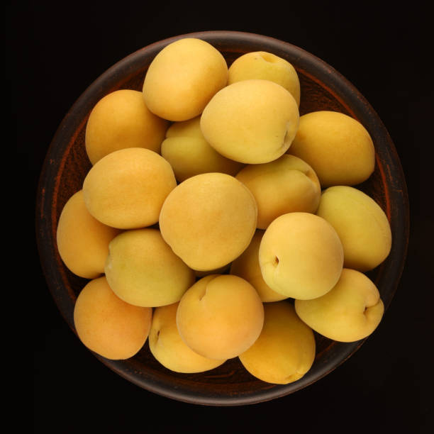 istock Apricot in a plate black background 1302627469