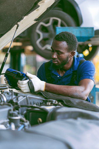 Portrait of African professional staff working on maintenance inspection in the auto services tires services center