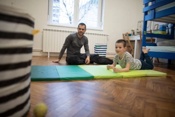 istock Father and son doing stretching exercises together at home 1302628299