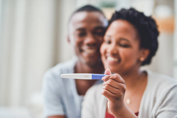 The butterflies he used to give me turned into little feet Cropped shot of a young couple smiling as she holds up a positive pregnancy test up family planning stock pictures, royalty-free photos & images