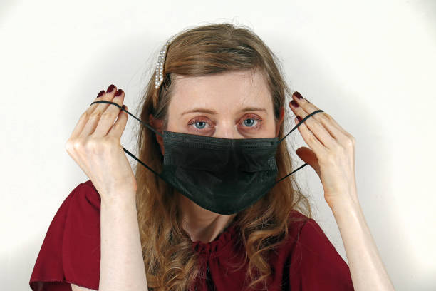istock Female putting face mask 1302628917