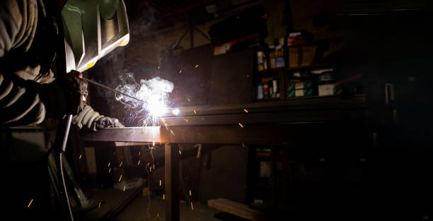istock A man with a protective mask on his head welds pipes in a workshop. 1302631112