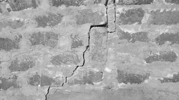 A large crack in the stone wall from the impact of the earthquake.