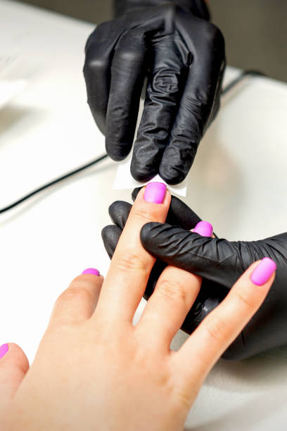 istock Manicurist applies a matte coating 1302632806