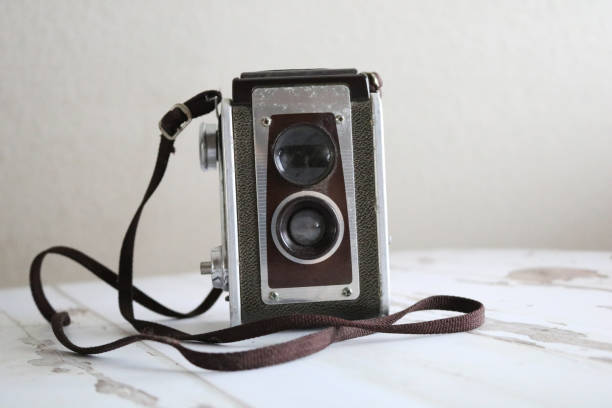 istock Old Dusty Beat-Up Vintage Film Camera on Table 1302634132