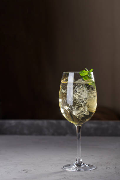 Hugo cocktail aperitif drink with Prosecco wine, lemon, mint and melissa syrup on dark background side view