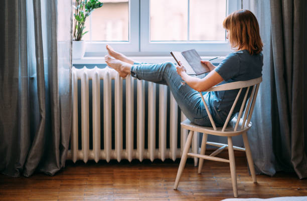 una joven que se toma un descanso de la tecnología - lifestyles women material indoors fotografías e imágenes de stock