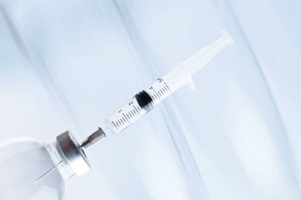 istock medicine bottle with a syringe stuck into the cap 1302638725