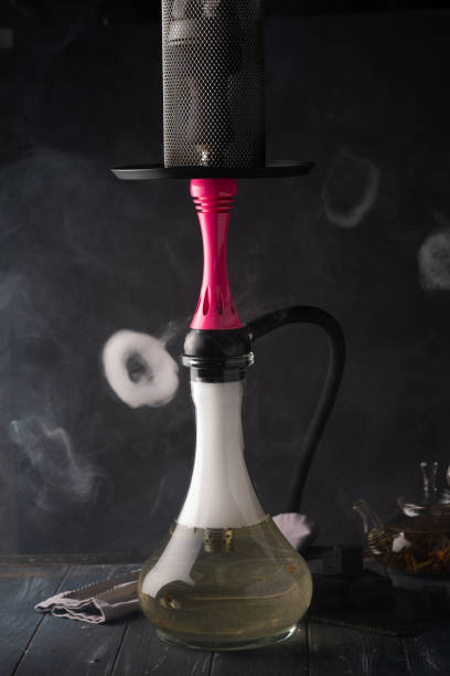 istock Smoking hookah on a black wooden background 1302639981