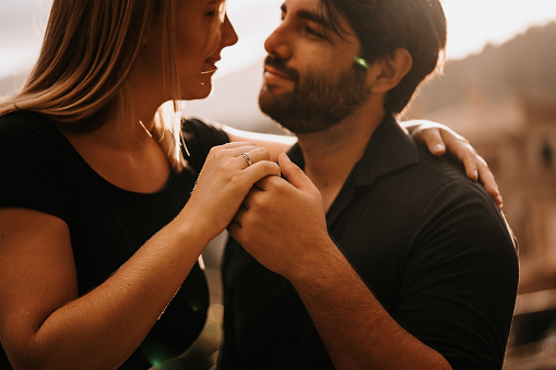 Close up of an engaged couple holding hands. Creative editing with grain. Part of an E+ and S+ series.