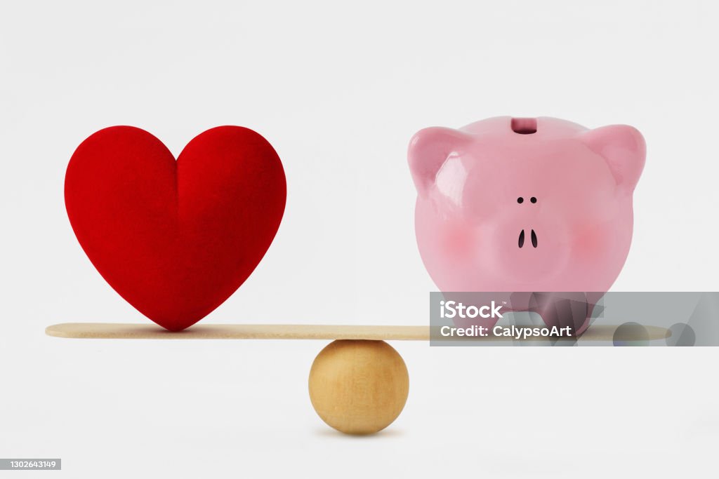 Heart and piggy bank on balance scale - Balance between love and money Heart Shape Stock Photo