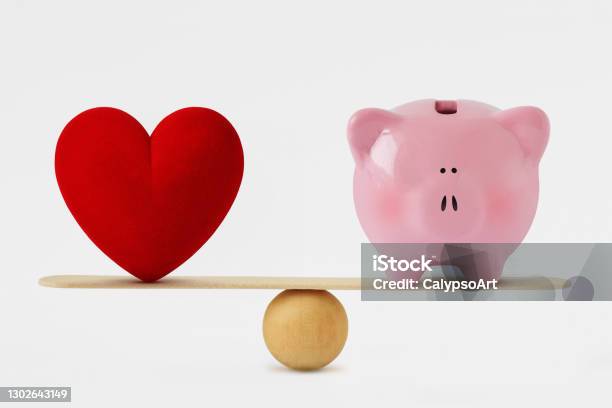 Heart And Piggy Bank On Balance Scale Balance Between Love And Money Stock Photo - Download Image Now