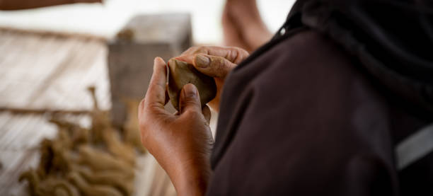 la mano di una donna scolpisce un'argilla a forma di cuore - shaping clay foto e immagini stock