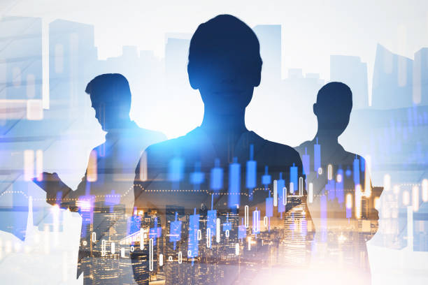 Silhouettes of three business people in blurry city with double exposure of financial charts. Toned image