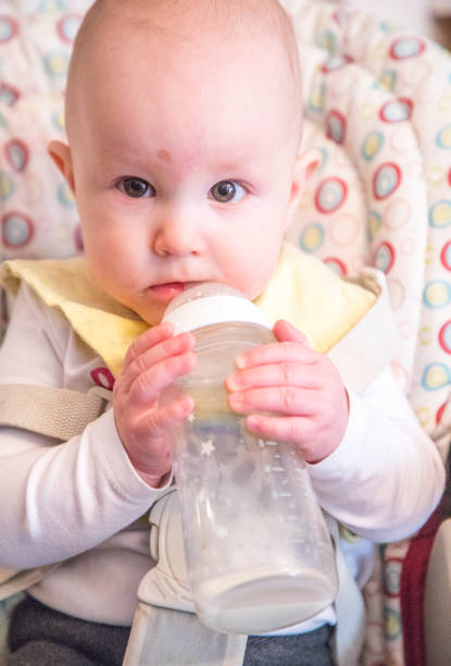 istock Child drinking milk from bottle 1302646130
