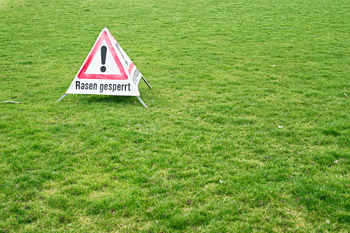 warning sign saying lawn closed in german language