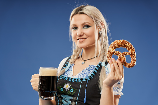 Blonde German young woman in traditional costume with a pint of beer