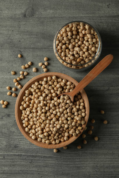 istock Bowl, jar and spoon with chickpea on gray table 1302646600