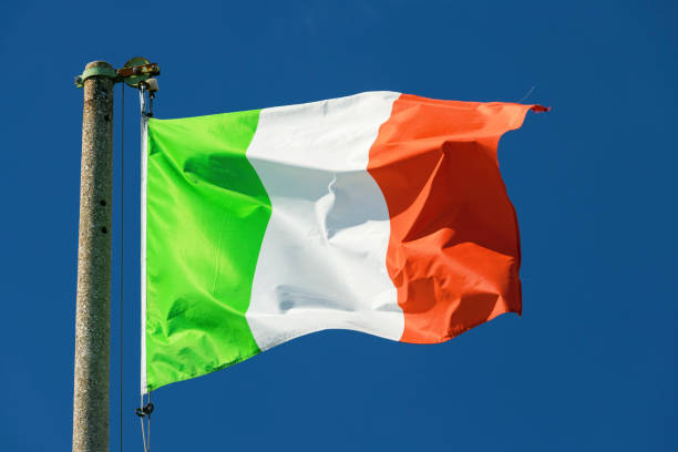istock Italian flag blowing in the wind in the blue sky 1302647144
