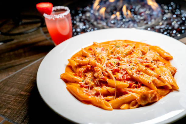 Penne Pasta Alla Vodka Italian Dinner with a Cocktail in the Background