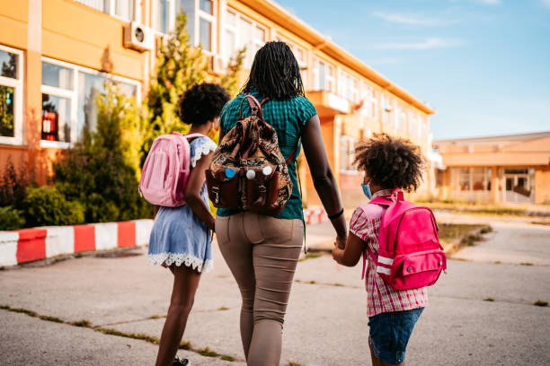 istock Mother taking her daughters to school 1302647672