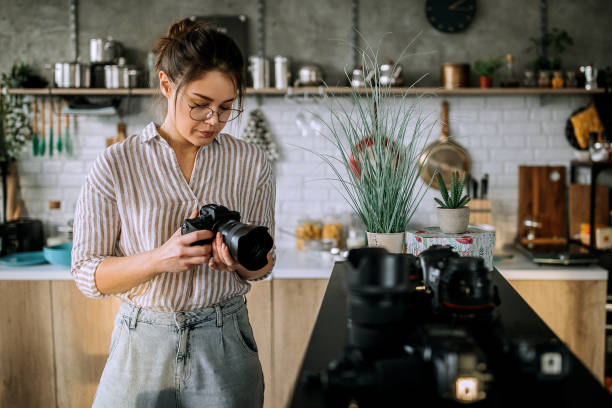 istock Young female photographer changing lense in her studio office 1302648804